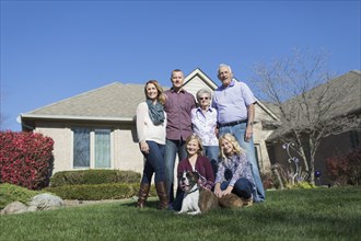 Caucasian multi-generation family smiling in yard