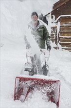 Caucasian man pushing snow blower