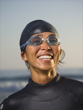 Asian woman wearing wetsuit and goggles