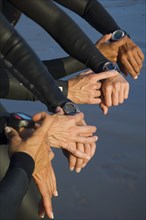 Multi-ethnic swimmers checking watches
