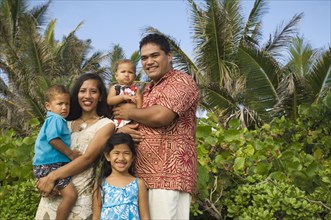 Pacific Islander family in front of palm trees