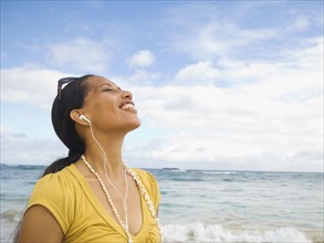 Pacific Islander woman listening to mp3 player