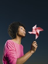 African woman blowing pinwheel