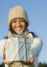 Mixed race businesswoman holding gift