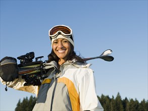 Mixed race woman holding skis