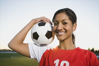 Mixed race woman posing with soccer ball