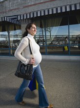 Pregnant Middle Eastern woman carrying shopping bags