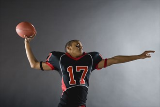Mixed race quarterback throwing football