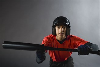 Mixed race baseball player ready to bunt with baseball bat