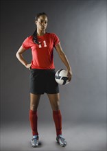 Mixed race soccer player holding soccer ball