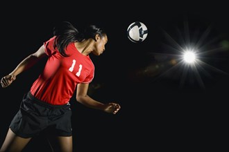 Soccer ball above mixed race soccer player