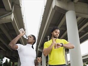 Runners taking a break under freeway overpass
