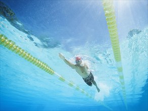 Mixed race man swimming in swimming pool