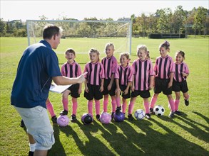 Coach motivating girl soccer players