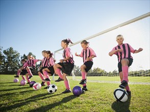 Girl soccer players practicing near net