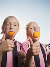 Caucasian girl soccer players eating orange slices