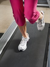Caucasian woman's legs running on treadmill