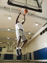 Black man shooting baskets on basketball court