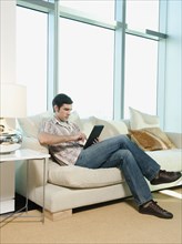 Caucasian man using digital tablet in living room