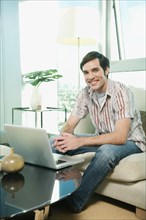 Caucasian man using laptop in living room