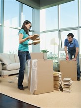 Couple packing boxes in living room