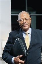 Black businessman in suit holding portfolio