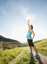 Pregnant Hispanic woman exercising in remote area