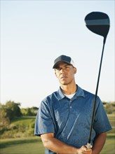 Black golfer holding golf club