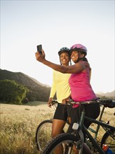 Friends taking self-portrait next to mountain bikes