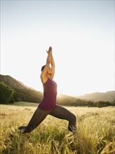 Mixed race woman practicing yoga in remote area