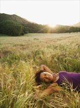 Mixed race woman laying in remote field