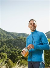 Athletic mixed race man drinking water outdoors