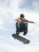 Caucasian man on skateboard in mid-air