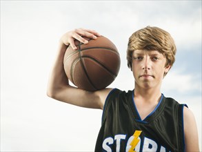 Caucasian teenager holding basketball