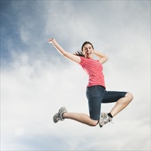 Caucasian teenager jumping in air