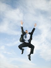 Caucasian businessman jumping in air
