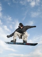 Caucasian man on snowboard in mid-air