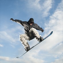 Caucasian man on snowboard in mid-air