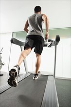 Mixed race man running on treadmill