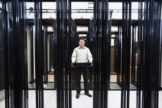 Asian businessman standing in empty server room