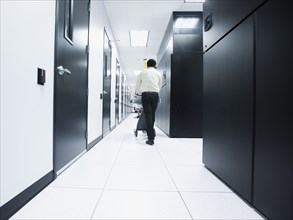 Asian businessman walking in server room