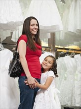Mixed race mother and daughter in dress store