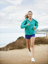 Caucasian woman running on beach