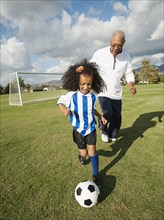 Man playing soccer with granddaughter