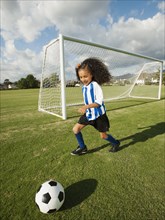 Mixed race girl playing soccer