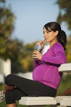 Pregnant Hispanic woman having health drink