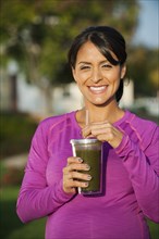 Pregnant Hispanic woman having health drink
