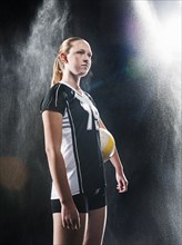 Caucasian volleyball player standing under lights