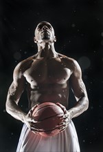 African American basketball player standing under lights