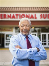 African American businessman smiling outside grocery store